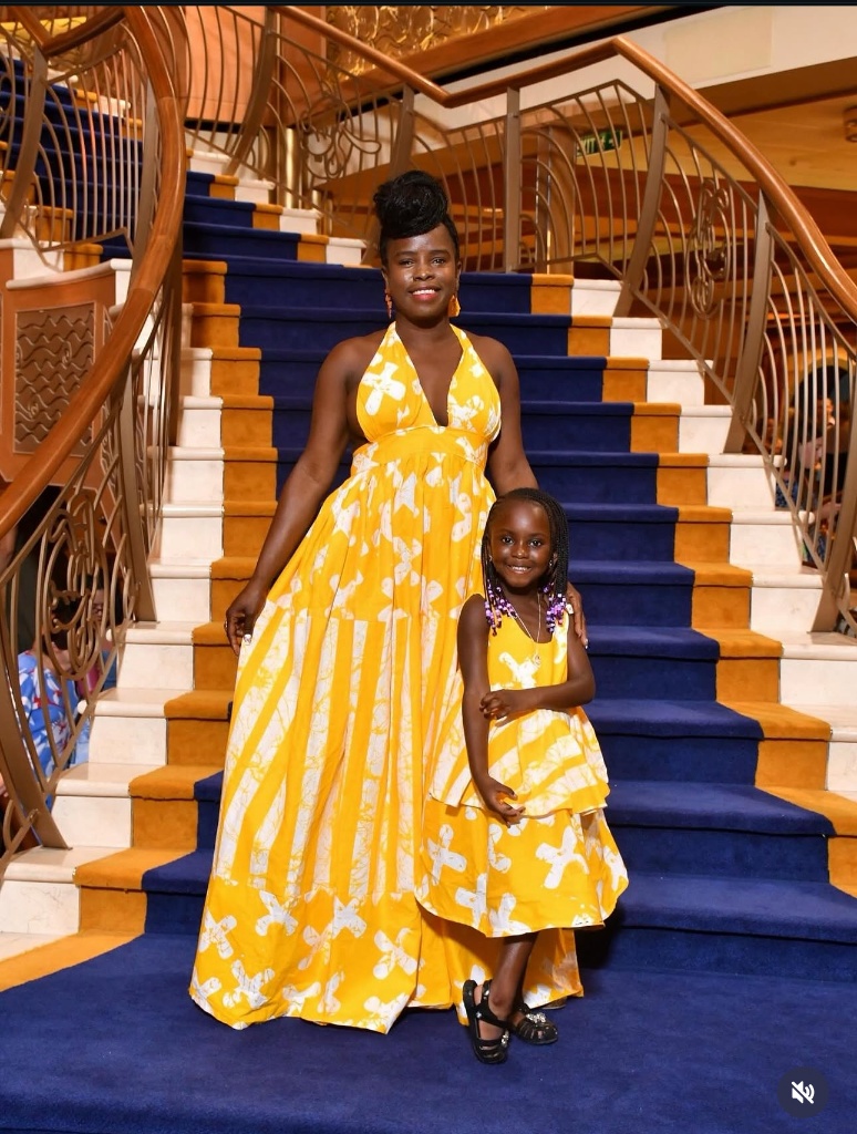 Mother and daughter in matching golden batik dresses, made by Minnie